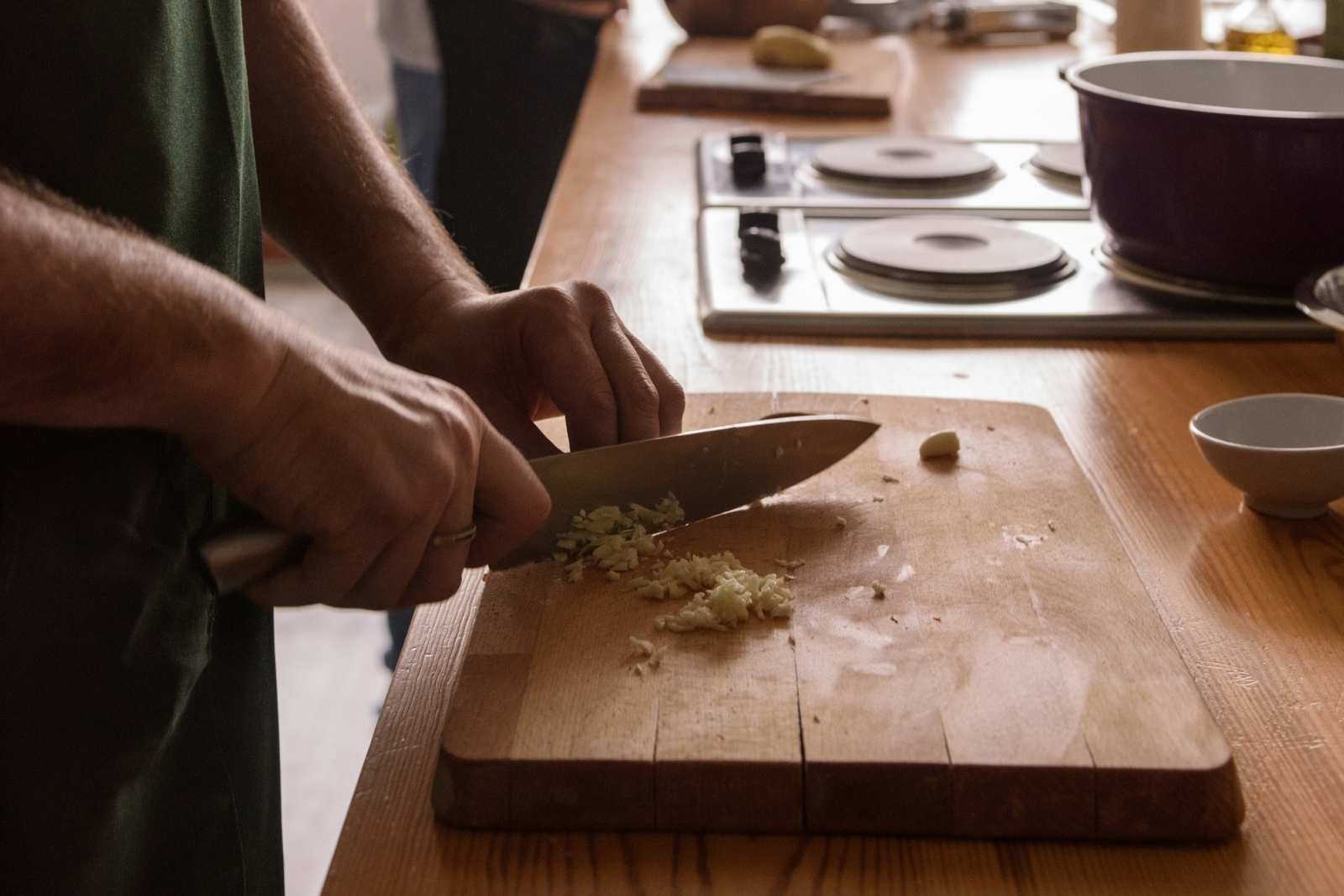 Food handler chopping food with a knife