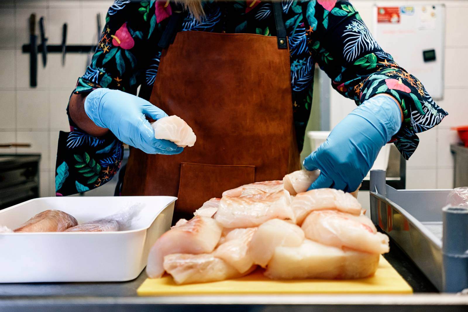 Food handler wearing gloves to work with meat safely