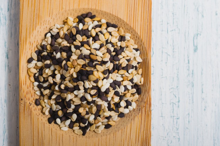 Bowl of sesame, a major food allergen, sitting on a table.